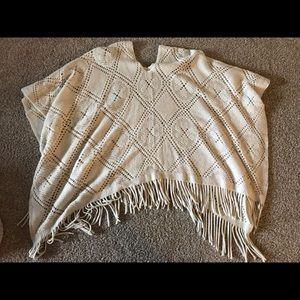 Cream, crocheted poncho with fringe at the bottom